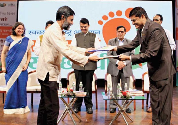Shriram Pawar (L), Chief Editor of Sakal Media Group, exchanged copies of the MoU with Swachh Maharashtra Movement Director Uday Tekale (R) in presence of Chief Minister Devendra Fadnavis (C), State Chief Secretary Swadhin Kshatriya (2nd from right) and Secretary, Urban Development Department Manisha Mhaiskar (left).